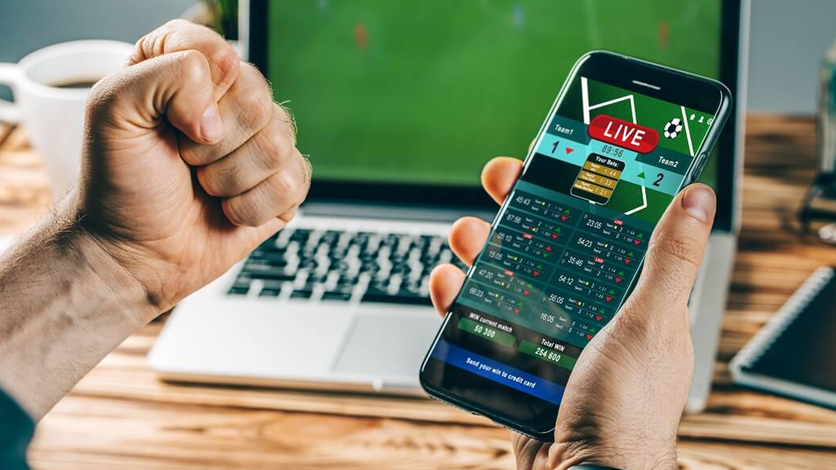 Apostas desportivas online. celular com campo de futebol na tela e